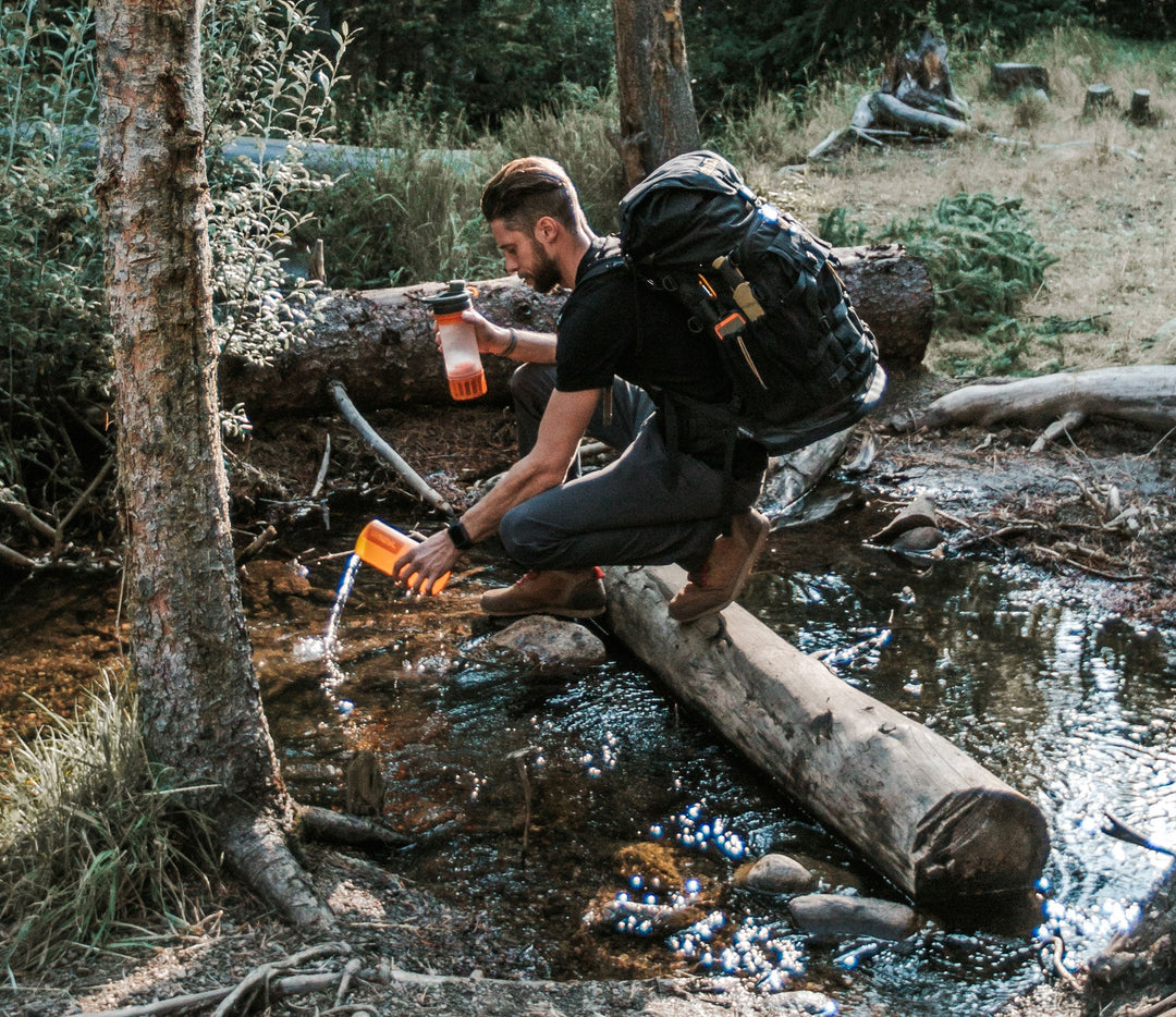 Ambassador Kyle Murphy filling up his Grayl in a wild river