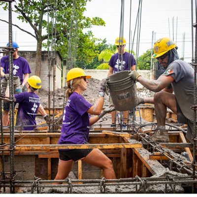 All Hands and Hearts volunteers pouring cement on a volunteer project.